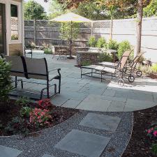 Traditional Patio with small bushes lining fence