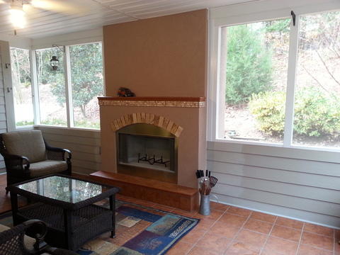 Eclectic Sunroom with beige stucco fireplace facing