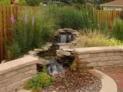 Traditional Landscape with short stone wall around patio