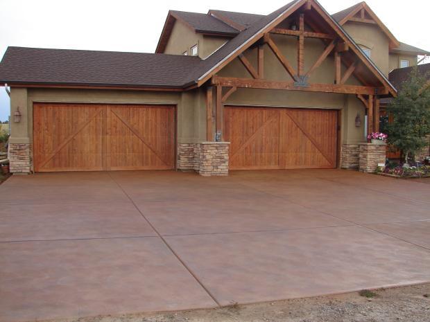 Traditional Driveway with dark stained wood garage doors