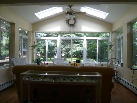 Transitional Sunroom with black metal side table and chair