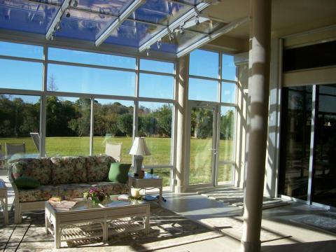 Traditional Sunroom with white wicker sofa with floral cushions