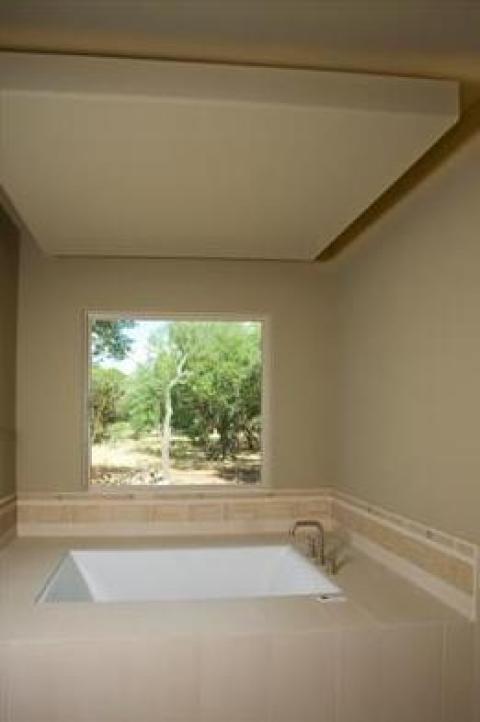 Transitional Master Bathroom with large window over tub
