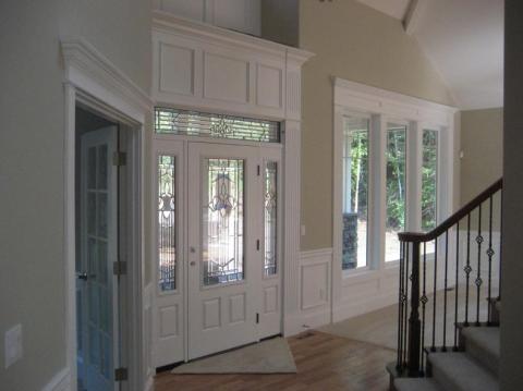 Traditional Entry with white wood cornice above doors