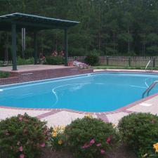 Traditional Pool with colorful flower bushes