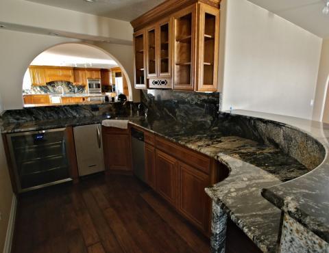 Eclectic Kitchen with bar is connected to the kitchen by an arched window