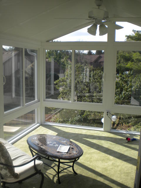 Traditional Sunroom with dark stained oval coffee table