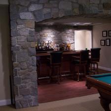Traditional Basement with black leather bar stools