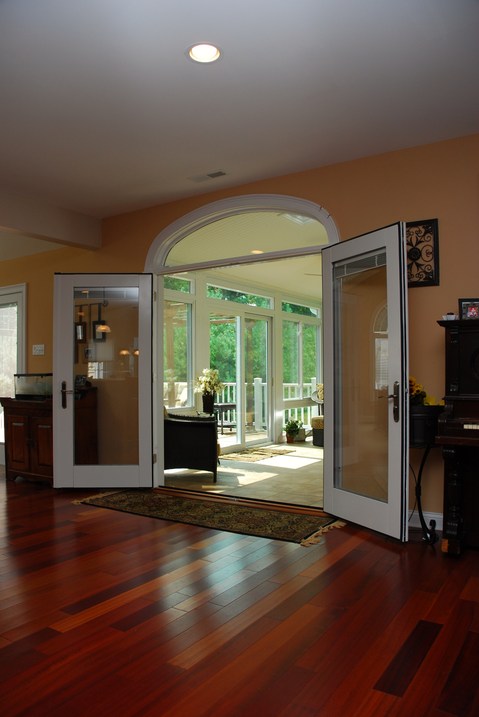 Traditional Sunroom with warm stained hardwood flooring