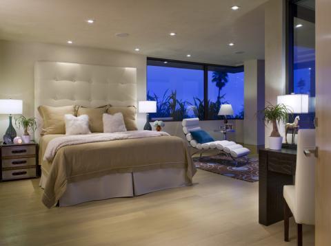 Transitional Bedroom with large white upholstered head board