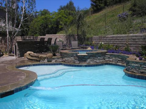 Traditional Pool with overflow from hot tub to pool