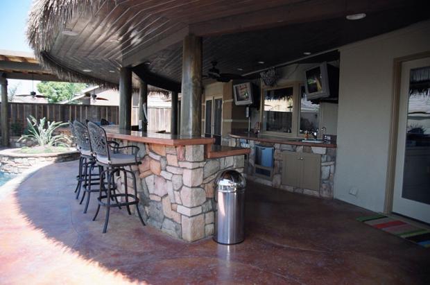 Tropical Outdoor Kitchen with dark wood roof over hang covering