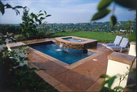Traditional Pool with stamped and tinted concrete pool surround
