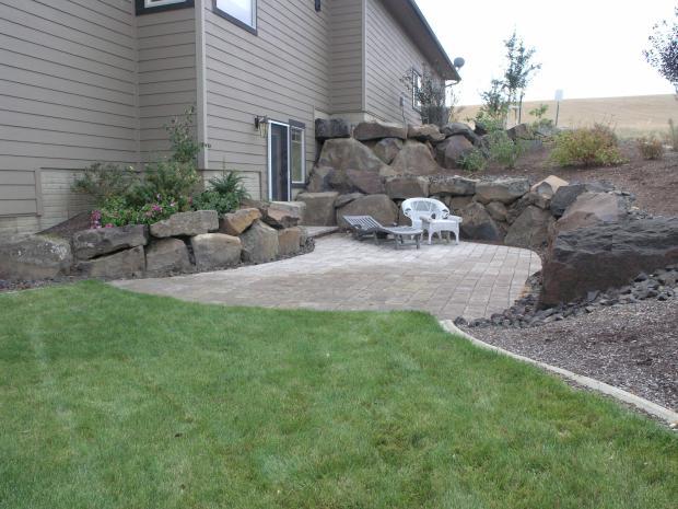 Transitional Patio with large landscape boulders lining patio