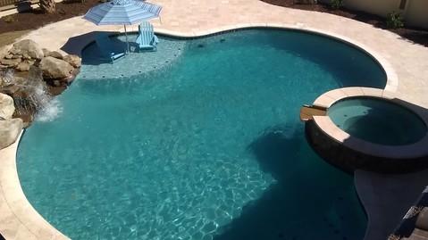 Traditional Pool with beige tile pool patio