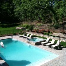Contemporary Pool with raised hot tub with stone exterior