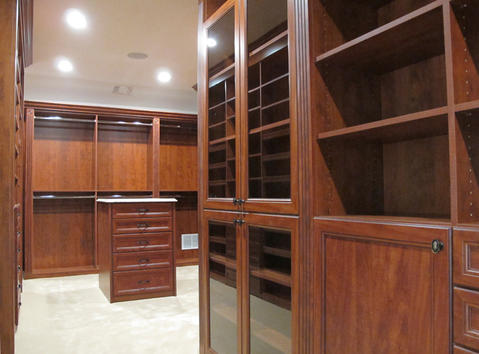 Traditional Closet with traditional style master closet with built in cabinetry and island