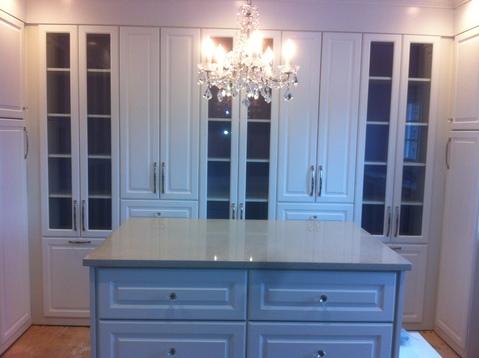 Cottage Closet with glass paneled cabinets