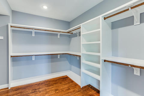 Transitional Closet with stained oak wood floor