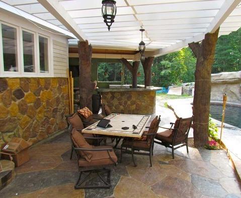 Eclectic Patio with tree trunk pergola supports