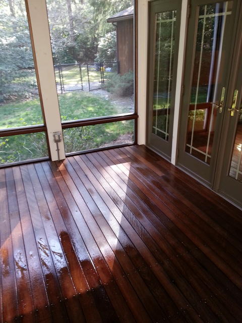 Transitional Sunroom with dark stained floor boards