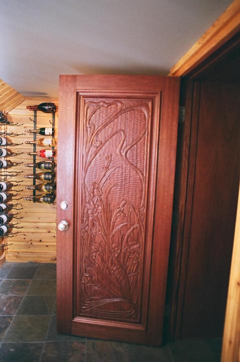 Eclectic Wine Cellar with hand carved wood door