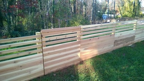 Modern Landscape with gate in a 6 foot horizontal slat and plank fence