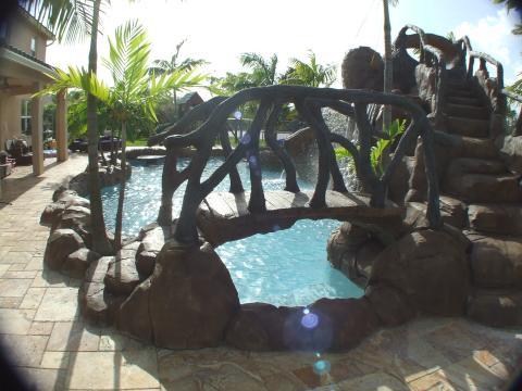 Eclectic Pool with tile patio around pool