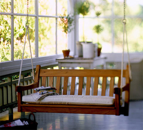 Cottage Sunroom with cream porch swing cushion
