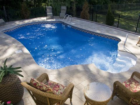 Traditional Pool with wicker towel hamper in shape of pineapple