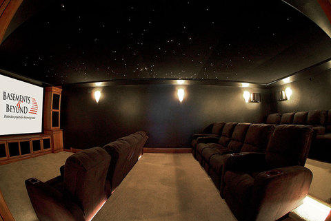 Traditional Home Theater with built in medium stained cabinetry
