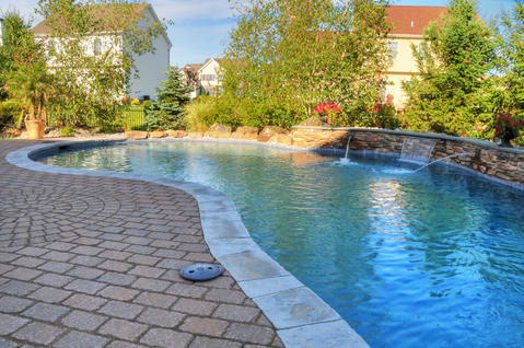 Traditional Pool with stone paver pool patio with decorative inlay