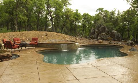 Traditional Pool with stamped concrete pool deck
