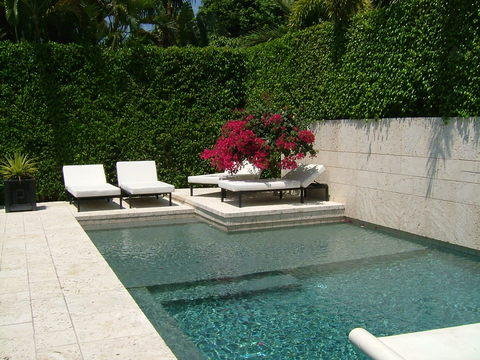 Contemporary Pool with white lounging pool chairs