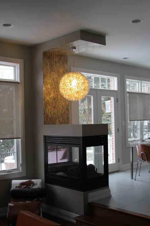 Transitional Dining Room with large sphere chandelier over fire place