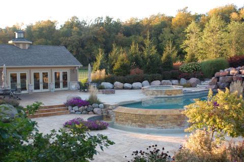 Traditional Pool with flower beds from rocks