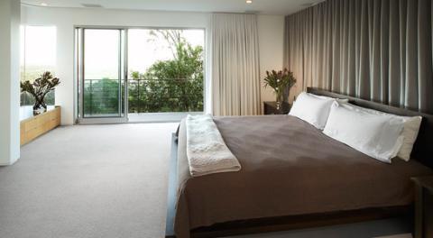 Contemporary Bedroom with long drapes behind head board