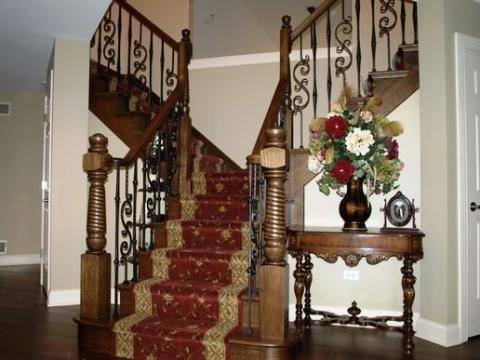 Traditional Staircase with red and gold runner on stairs