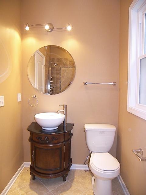 Traditional Powder Room with dark wood elegant vanity cabinet