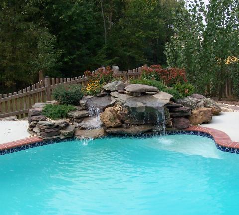 Traditional Pool with water feature into the pool