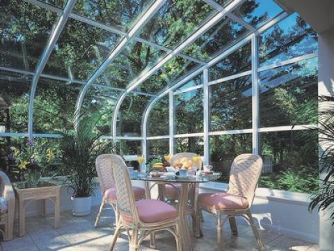 Traditional Sunroom with light red cushioned dining chairs