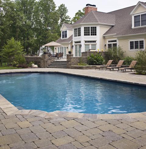 Traditional Pool with large pale yellow siding