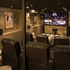 Eclectic Home Theater with black leather lounge chairs