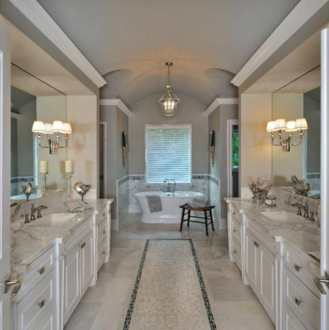 Transitional Bathroom with wall sconces mounted to mirrors