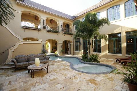 Traditional Pool with beige painted stucco exterior