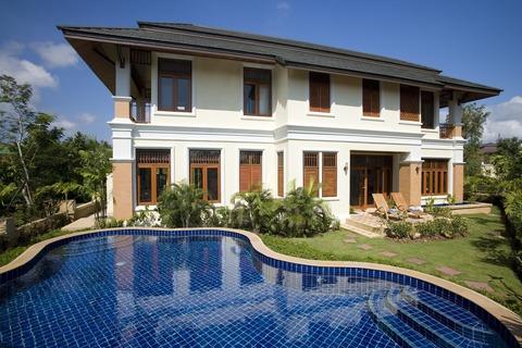 Traditional Home Exterior with large curvy in ground pool