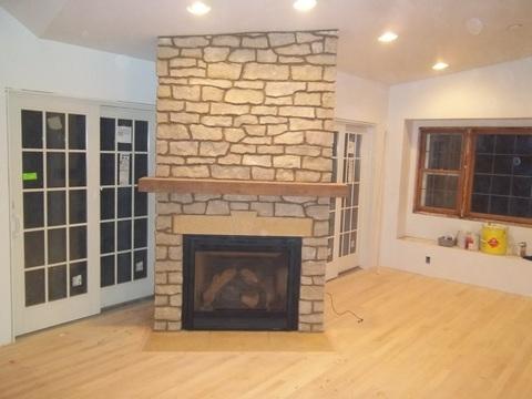 Contemporary Sunroom with stacked stone fireplace surround