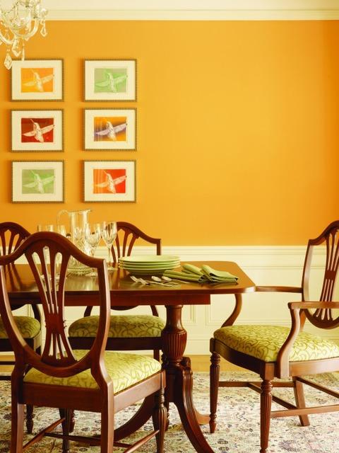Eclectic Dining Room with bright yellow-orange wall paint