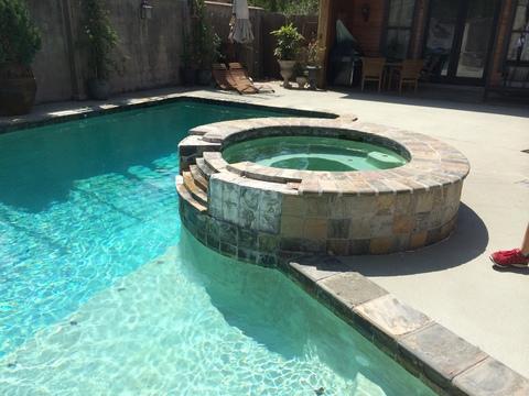 Transitional Pool with circular hot tub with stone surround