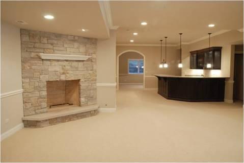 Transitional Basement with cream wall to wall carpet